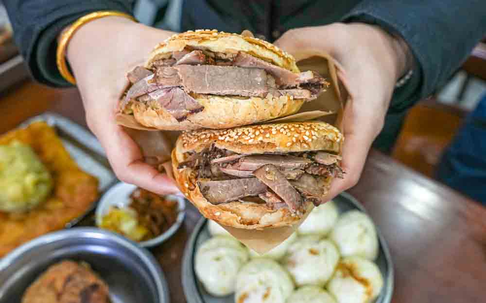 Guest holding meaty flatbread