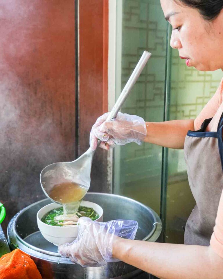 Vendor pouring Pho into bowl
