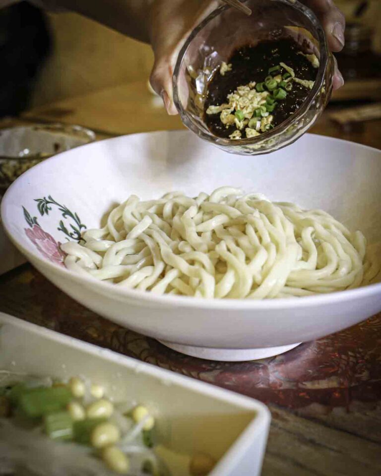 Mixing sauce into local noodles