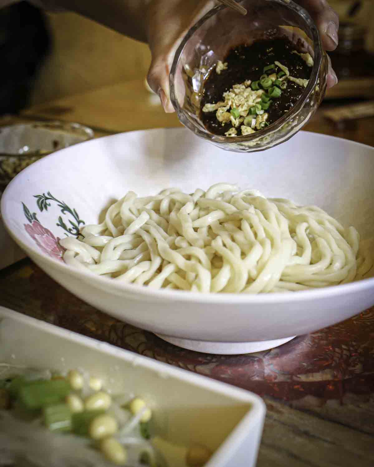 Mixing sauce into local noodles