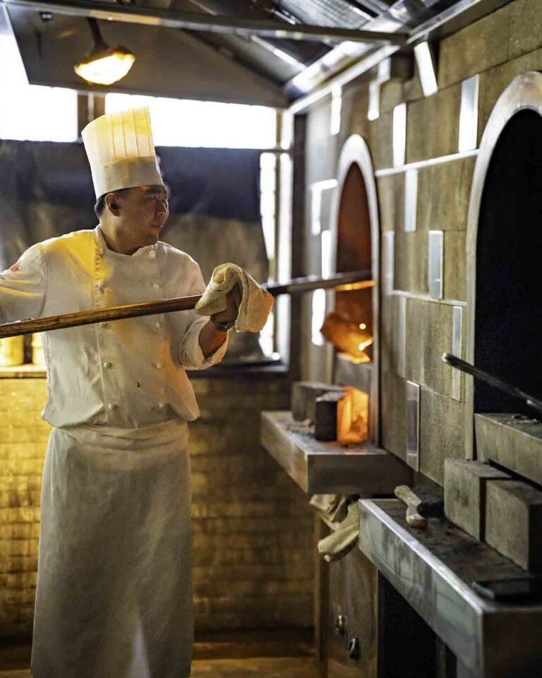 Chef roasting Peking Duck over fire