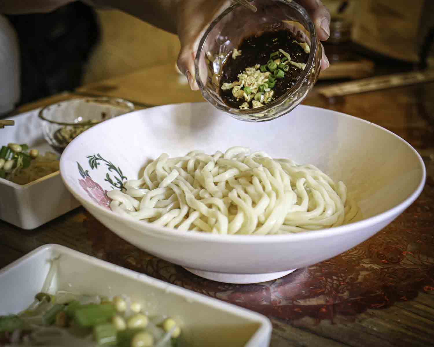 Pouring sauce on Beijing noodles