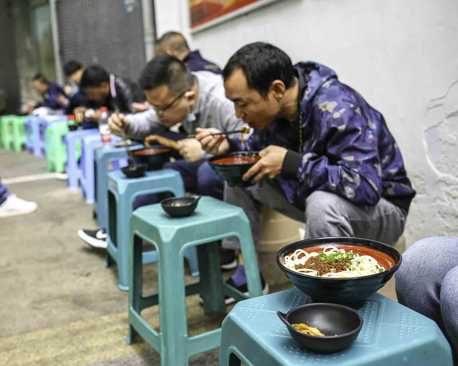 Locals eating noodles from stools
