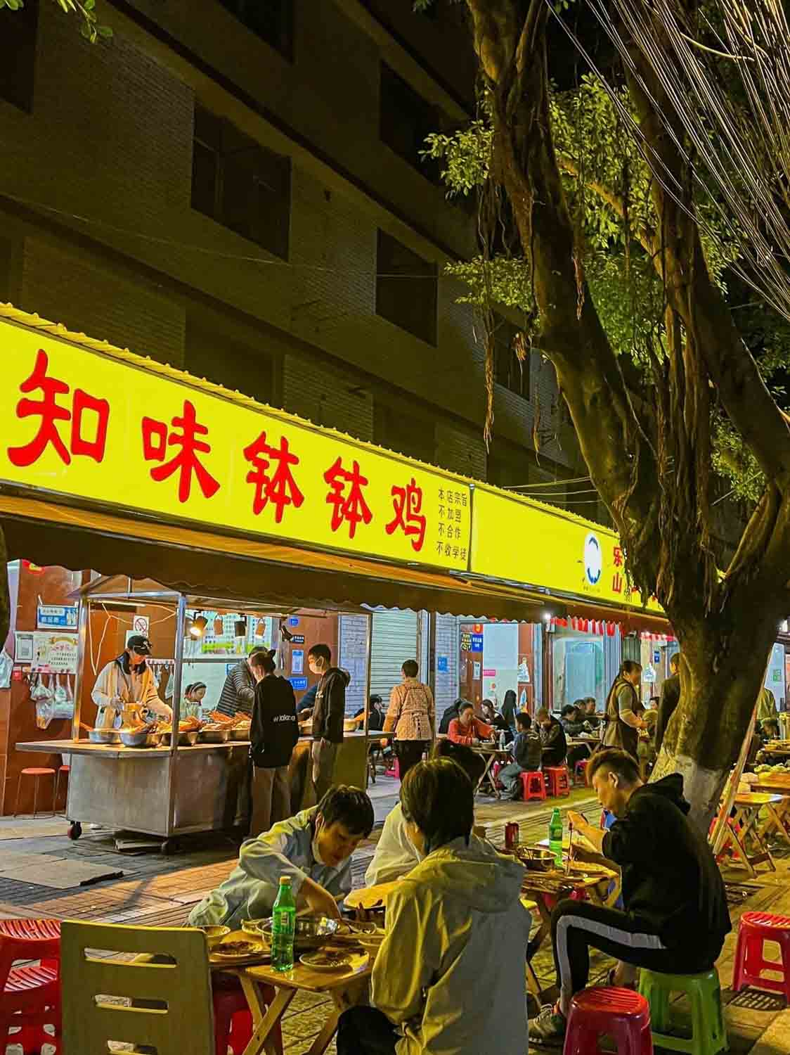 People eating on the street outside restaurant