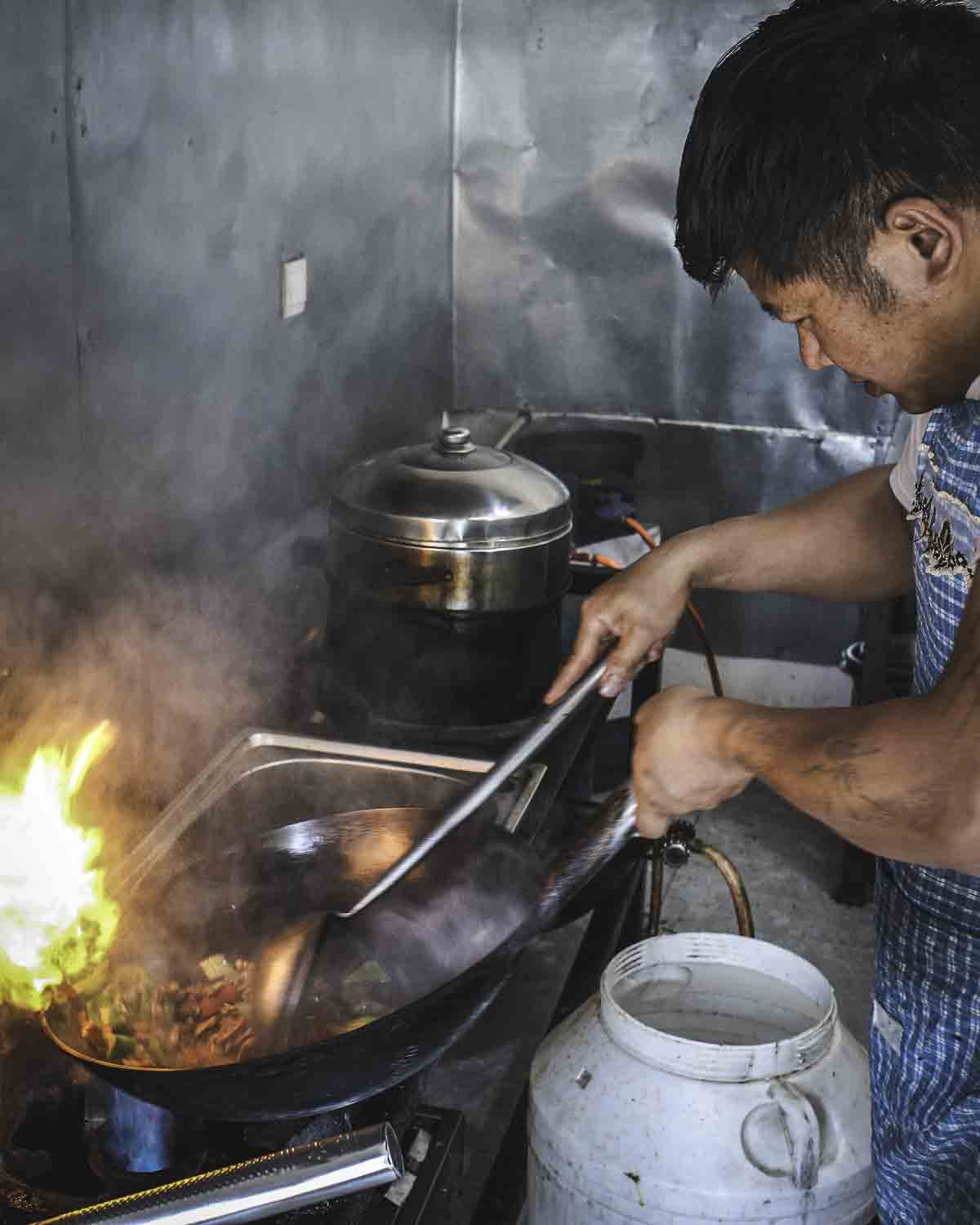 Chef stir-frying with fire